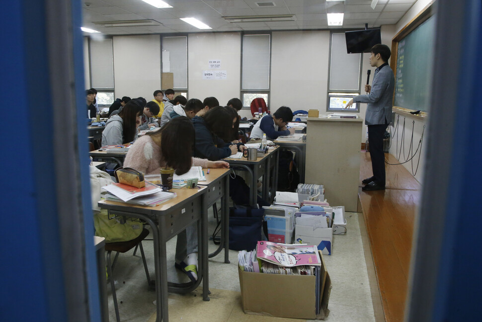 서울의 한 학원 수업 모습. 책상 앞에 사물함에 넣지 못한 참고서가 쌓여 있다. 한겨레 이정아 기자