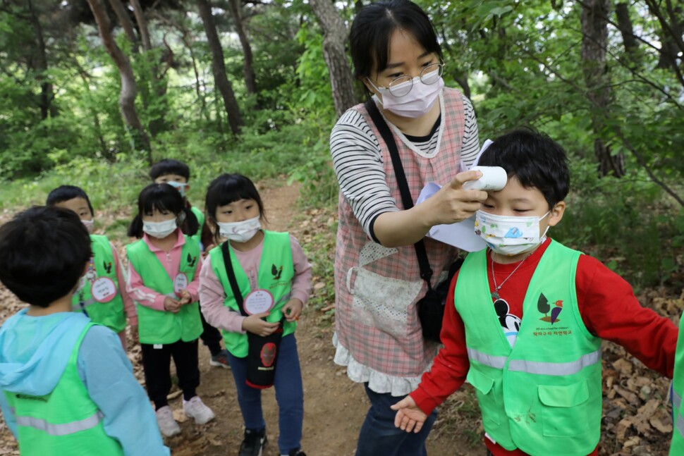 인천 남동구 논현동 늘솔길 근린공원 유아숲체험원을 찾은 어린이들이 숲체험에 앞서 어린이집 선생님에게 발열 검사를 받고 있다.