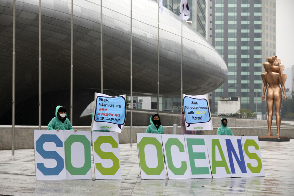 Members of Greenpeace hold a protest Friday in front of the Dongdaemun Design Plaza in Seoul to call on the South Korean government to designate 30 percent of the country’s ocean area as marine protected areas by 2030. (Kim Myoung-jin/the Hankyoreh)