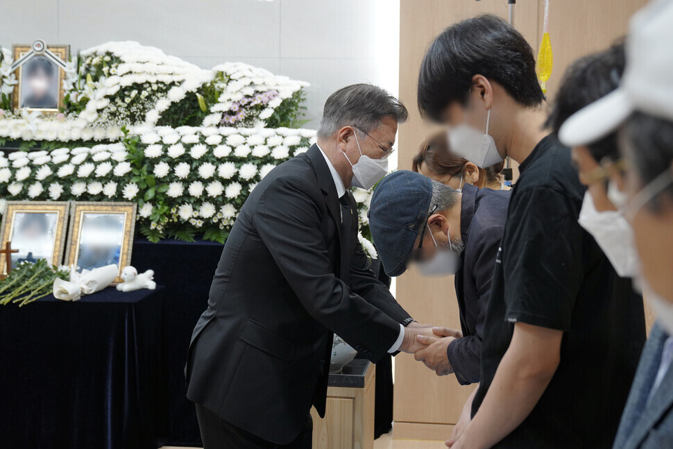 South Korea President Moon Jae-in, during his visit to the memorial for the Air Force master sergeant who died by suicide after being sexually assaulted by a fellow service member, consoles the victim’s family members on Sunday. (Yonhap News)