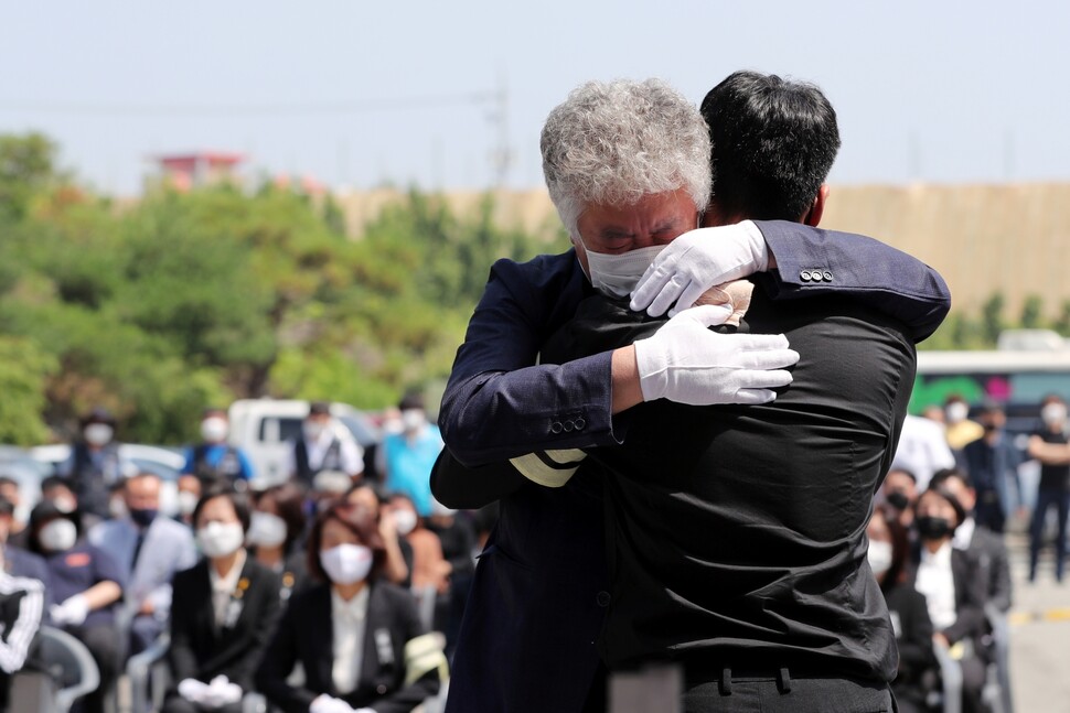 경기도 평택항에서 일하다가 산업재해로 숨진 이선호씨의 아버지 이재훈씨가 2021년 6월19일 평택시 안중백병원 장례식장에서 열린 아들의 장례식에서 추모사를 마친 아들의 친구를 안아주고 있다. 이선호씨의 장례는 59일 만에 치러졌다. 연합뉴스