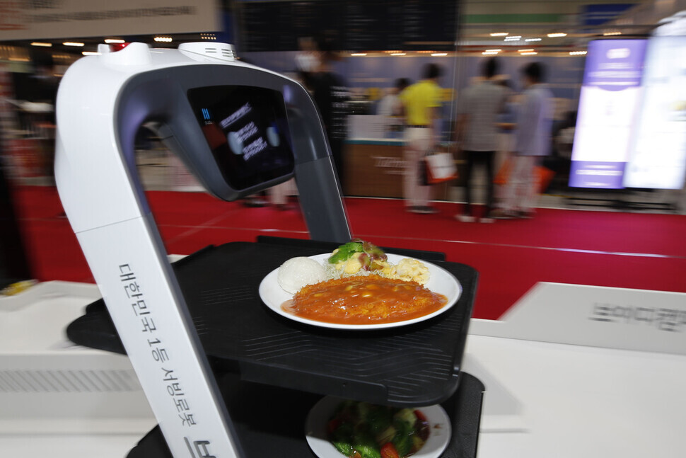 A self-driving serving machine is test-delivering food for visitors at the International Franchise Show held at Coex in Seoul on Thursday. (Lee Jeong-a/The Hankyoreh)