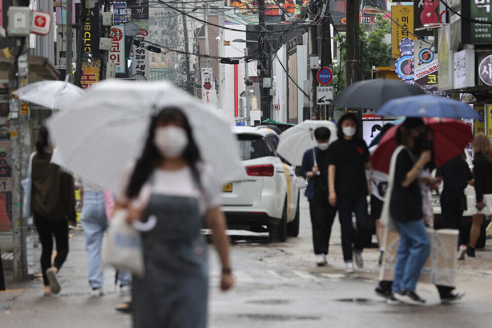 People wearing protective masks walk on a street in Seoul on Sunday. (Yonhap News)