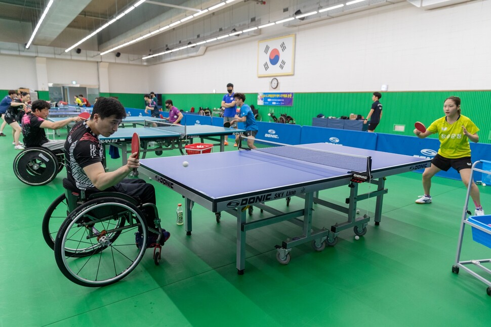 휠체어탁구 종목의 김영건 선수(왼쪽 맨 앞)가 비장애인 선수를 상대로 훈련하고 있다. 김 선수는 2012 런던패럴림픽 휠체어탁구 클래스4 종목에서 금메달을 땄다.