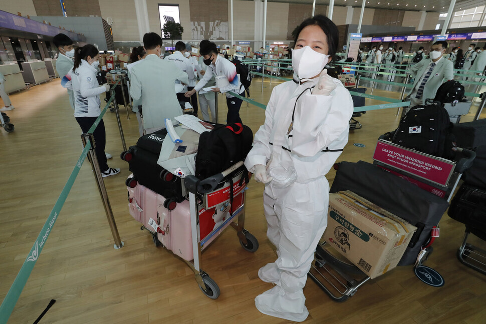 Team Korea table tennis player Shin Yu-bin poses for a photo in a protective suit before leaving for Japan on Monday. (Lee Jeong-a/The Hankyoreh)