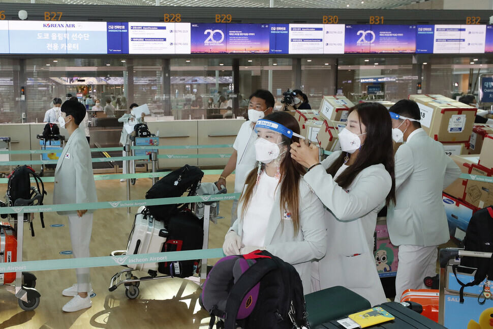 Team Korea athletes wait in line at Incheon International Airport on Monday. (Lee Jeong-a/The Hankyoreh)