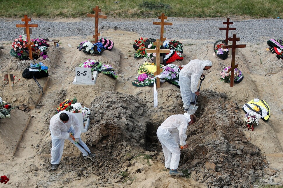 2021년 6월 러시아 상트페테르부르크 외곽의 묘지에서 일꾼들이 코로나19 방역을 위해 개인 보호장구를 착용한 채 작업하고 있다. REUTERS 연합뉴스
