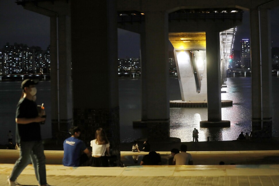 서울 낮 최고기온이 34도까지 올라간 7월18일 밤 10시31분, 서울 여의도동 원효대교 아래 한강 둔치에서 더위를 피해 나온 사람들이 거리두기를 하느라 드문드문 앉아 여름밤을 보내고 있다.