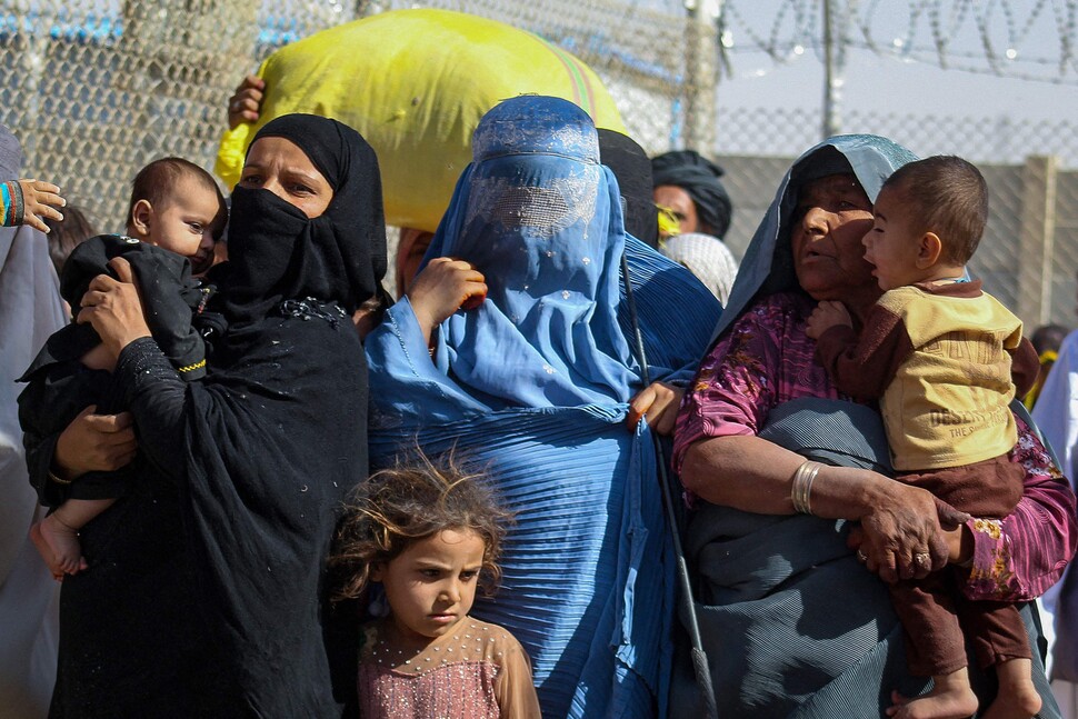탈레반 군대가 점령한 이후 국경을 넘어 2021년 8월24일 파키스탄에 도착한 아프가니스탄 여성과 아이들 모습. 가운데 여성은 부르카를 쓰고 있다. AFP 연합뉴스