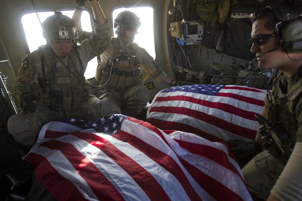 US Air Force pararescuemen ride in their medivac helicopter with the bodies of US soldiers who were killed in a roadside bomb attack in Afghanistan on Oct. 10, 2010. (AP/Yonhap News)
