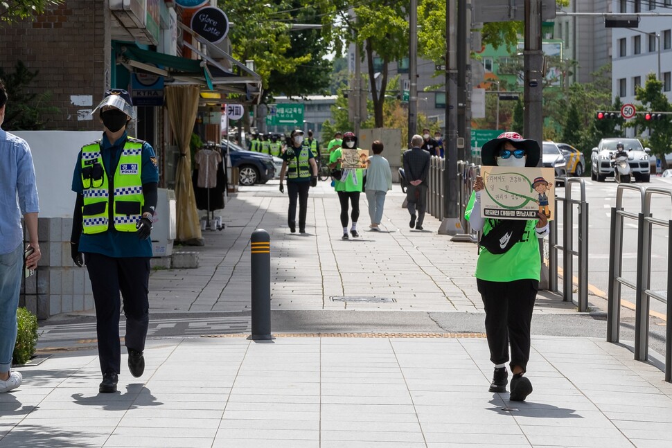9월4일 행진이 서울 중심부로 들어서자 노동자 한 명에 경찰 한 명이 붙어 광화문 거리를 함께 걷고 있다.