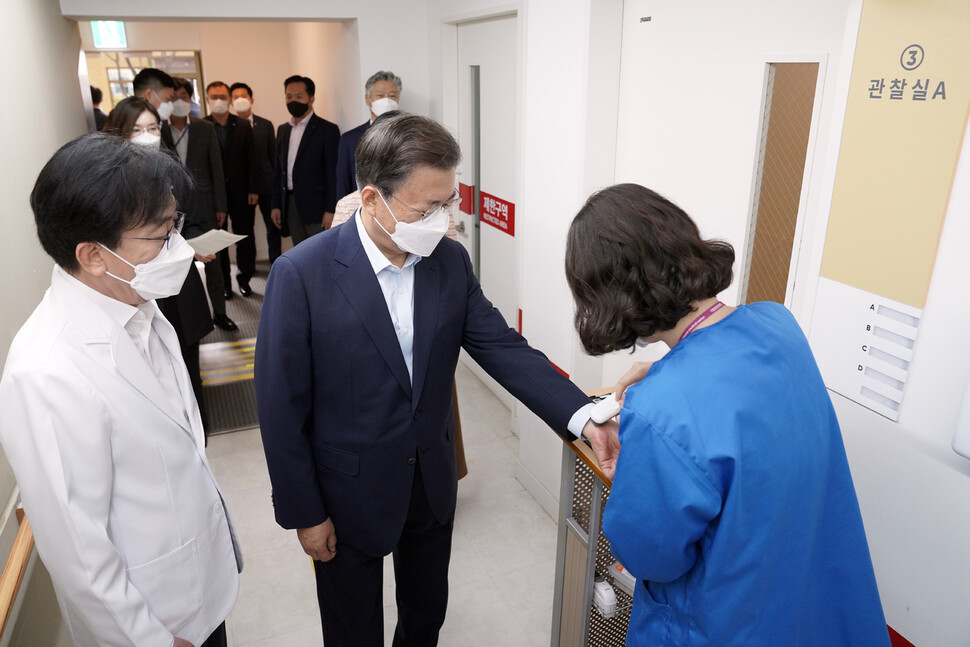 문재인 대통령이 15일 코로나19 추가 접종을 받기위해 서울 국립중앙의료원 코로나19 중앙예방접종센터로 들어서며 체온측정을 하고 있다. 연합뉴스