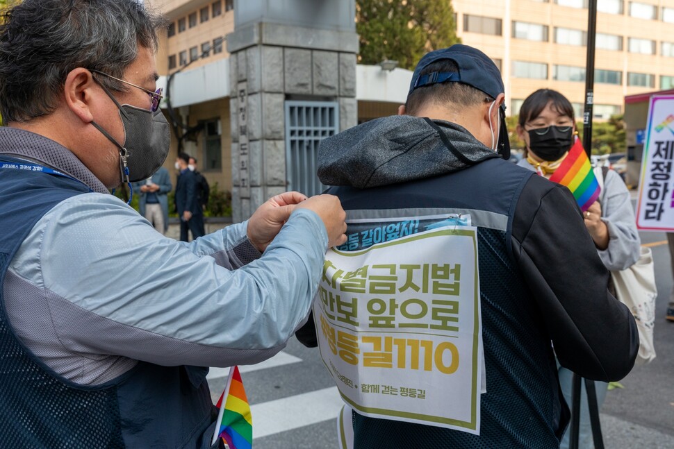 차별금지법 제정에 뜻을 함께한 민주노총 노동자들이 출발에 앞서 서로 펼침막을 달아주고 있다.