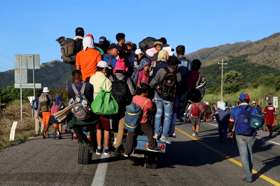 멕시코 오악사카주 아리아가에서 멕시코시티로 향하는 이주민들이 11월7일 트럭 짐칸이 넘쳐 범퍼에까지 올라탄 채 달리고 있다.