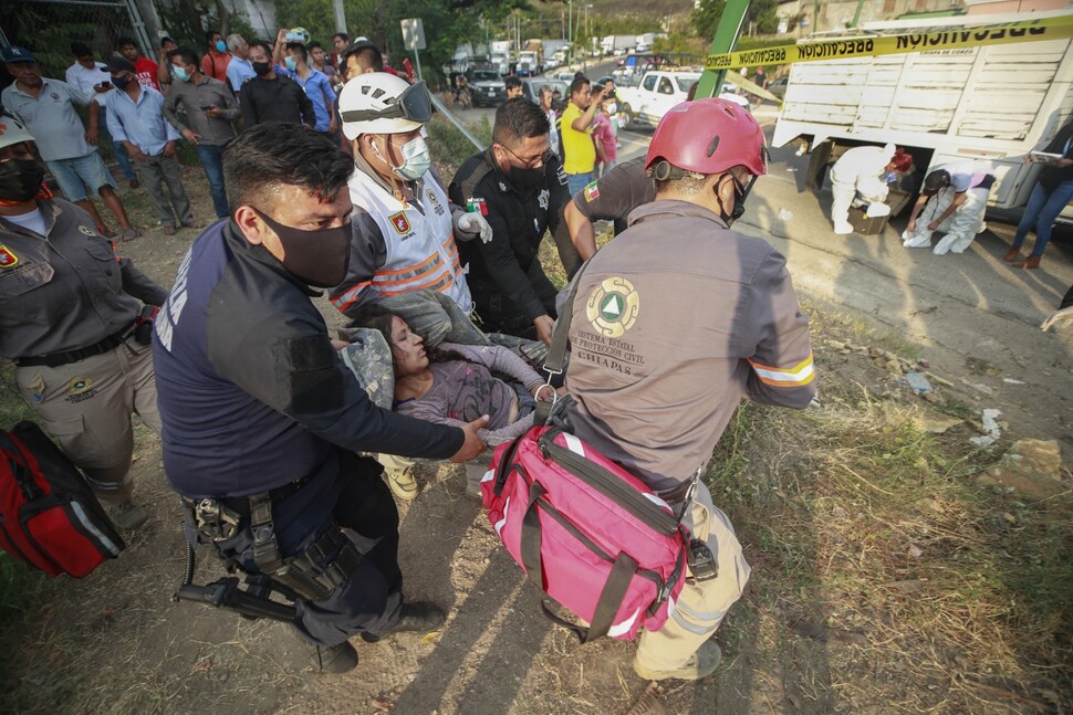 멕시코 치아파스주 툭스틀라구티에레스에서 12월9일 이주민 200여 명이 탄 트럭이 뒤집혀 구급대원들이 부상자를 옮기고 있다. 이 사고로 54명(9일 집계)이 숨졌다.