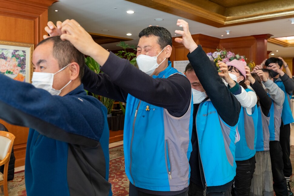 해고노동자들이 농성 중 동료의 머리를 마사지하고 있다.