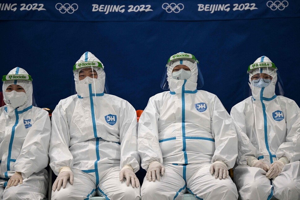 個人用防護服を着たオリンピック主催者が待っています。  AFP聯合ニュース