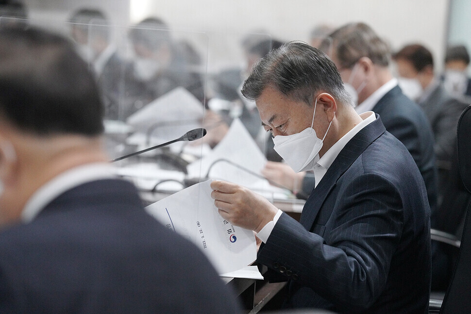 South Korean President Moon Jae-in checks a handout at a joint meeting of the National Security Council and an economic security strategy council at the Blue House on Tuesday. (provided by the Blue House)