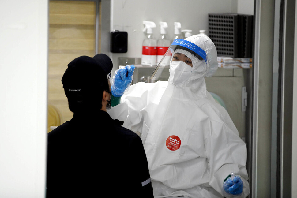 A medical worker takes a sample from an individual to be tested for COVID-19 infection on March 17 in Gwangju. (Yonhap News)