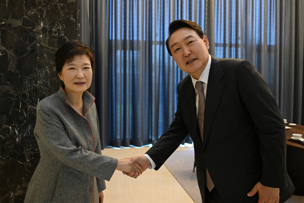 Former President Park Geun-hye, left, shakes hands with President-elect Yoon Suk-yeol at her home in Daegu on April 12. (provided by the office of Yoon’s spokesperson)