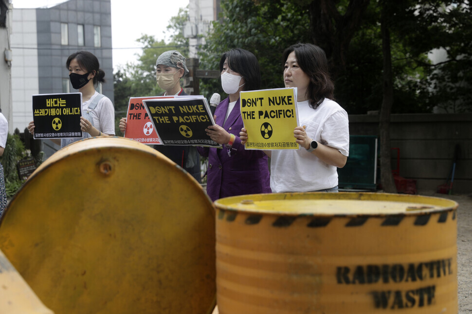 Lawmaker Yoon Mee-hyang (second from right) takes part in a joint action calling on Japan to revoke its plan to dump contaminated water from the Fukushima nuclear plant stage a depiction of radioactive waste spreading in the waters around Japan on June 8 in Seoul. (Kim Myoung-jin/The Hankyoreh)