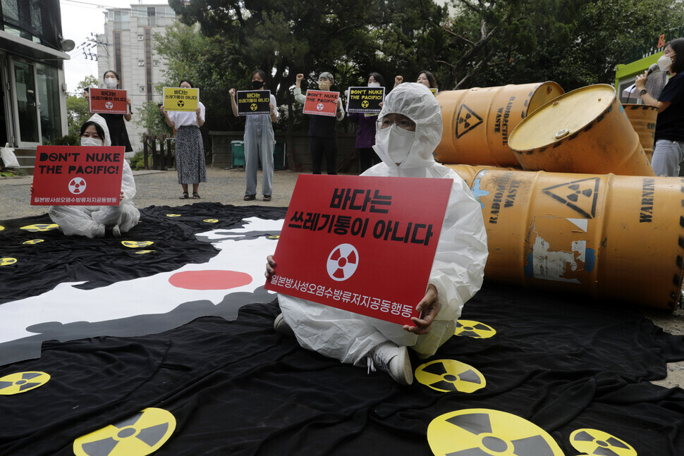 Demonstrators taking part in a joint action calling on Japan to revoke its plan to dump contaminated water from the Fukushima nuclear plant stage a depiction of radioactive waste spreading in the waters around Japan on June 8 in Seoul. (Kim Myoung-jin/The Hankyoreh)