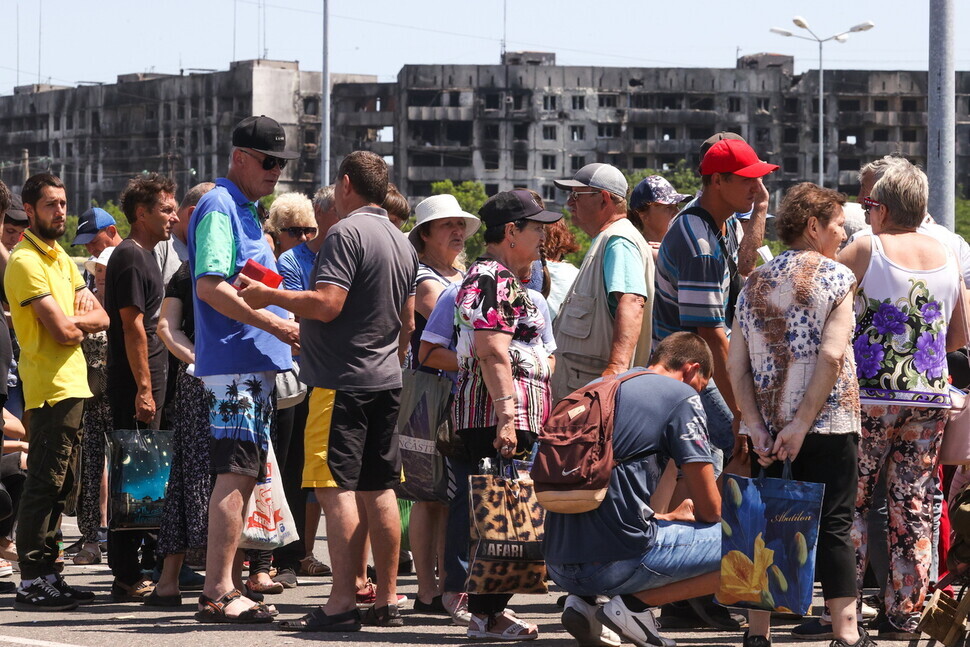 Locals wait in line at a humanitarian food bank in Mariupol, Ukraine, on June 10, 2022. (TASS/Yonhap News)