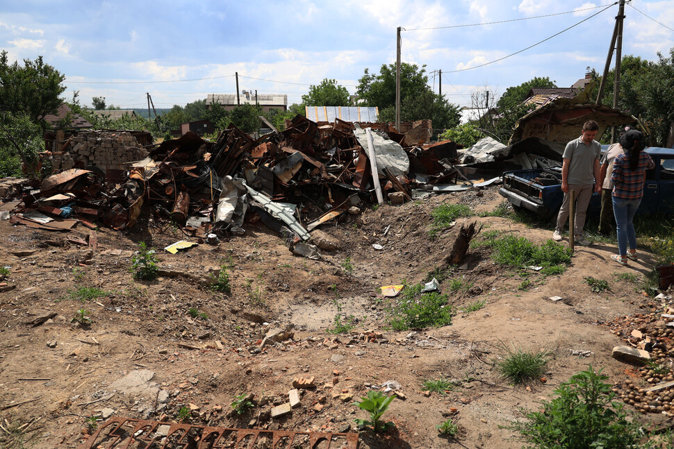 우크라이나 보로댠카 법원 뒤 빈터에 건축물 잔해만 남았다. 6월17일 이웃 주민들이 집의 형태가 전혀 남지 않은 주변을 돌아보고 있다. 이곳에 살던 여성은 숨졌다.
