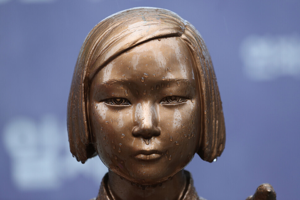 The Statue of Peace, a memorial to victims of the comfort women system of sexual slavery, sits in the rain on July 13 in downtown Seoul. (Kang Chang-kwang/The Hankyoreh)