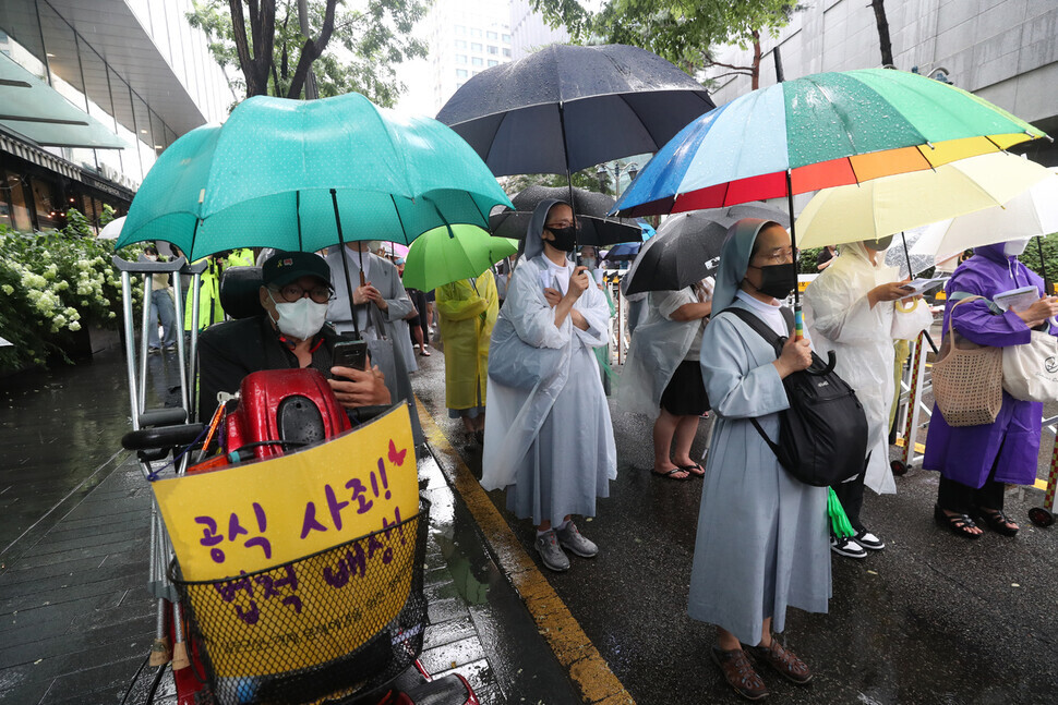 Participants in the 1,552nd Wednesday Demonstration hold umbrellas to shelter them from the rain. (Kang Chang-kwang/The Hankyoreh)
