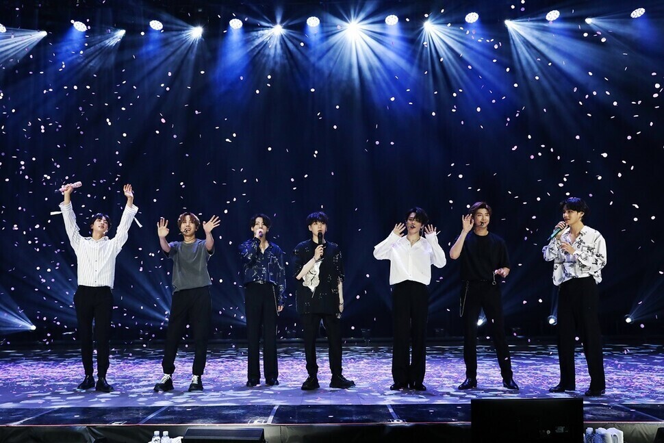 BTS waves to a crowd during a performance. (courtesy Bighit Music)