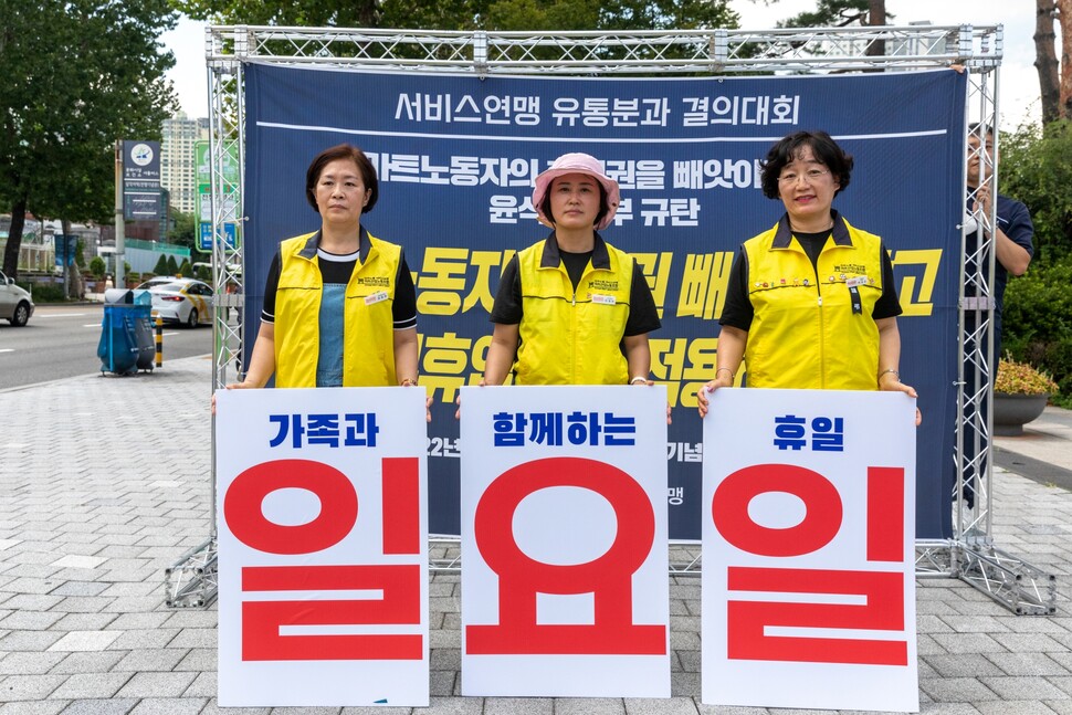 (왼쪽부터) 공윤란 마트노조 홈플러스지부 서울본부장, 유영란 롯데마트지부 수석부위원장, 박상순 이마트지부 부위원장이 2022년 8월23일 서울 용산 대통령집무실 앞 거리에서 정부의 ‘마트 의무휴업일 폐지’ 추진에 반대하며 ‘가족과 함께하는 휴일’이란 팻말을 들고 있다. 박승화 기자