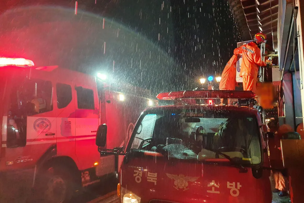 Firefighters take down a sign at risk of blowing off of a commercial building in Gyeongju during Typhoon Hinnamnor on Sept. 5. (courtesy Gyeongbuk Fire Service Headquarters)