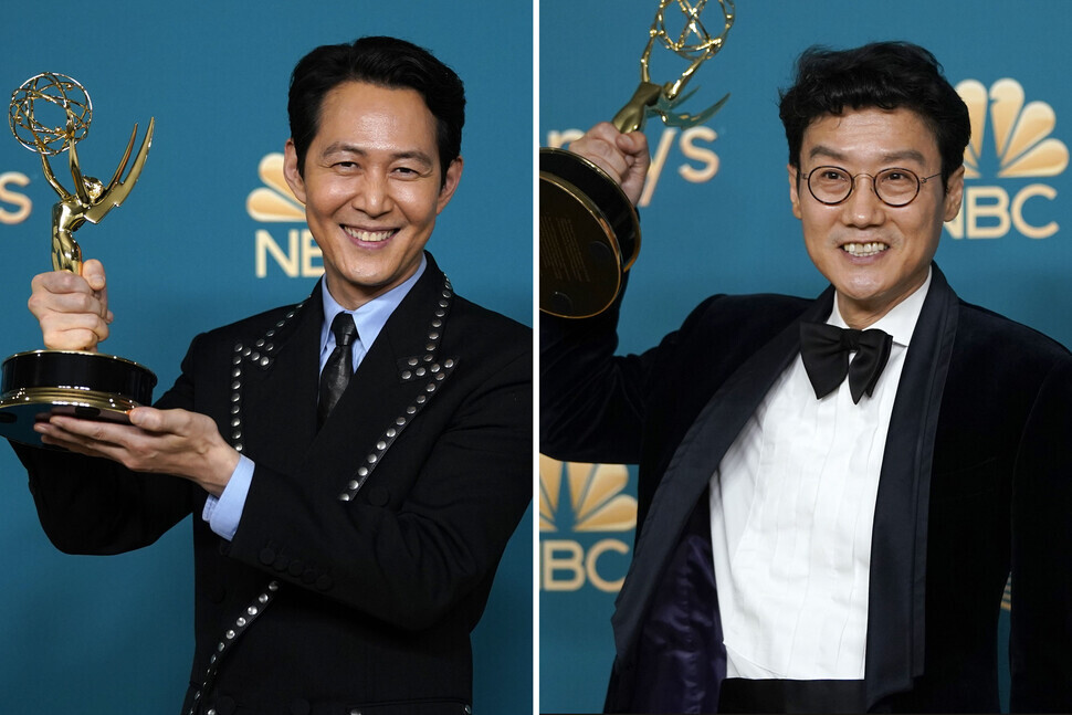 “Squid Game” lead actor Lee Jung-jae (left) and director Hwang Dong-hyuk (right) hold up their respective Emmy trophies after winning at the 74th Primetime Emmy Awards on Sept. 12 in Los Angeles’s Microsoft Theater. (AP/Yonhap)