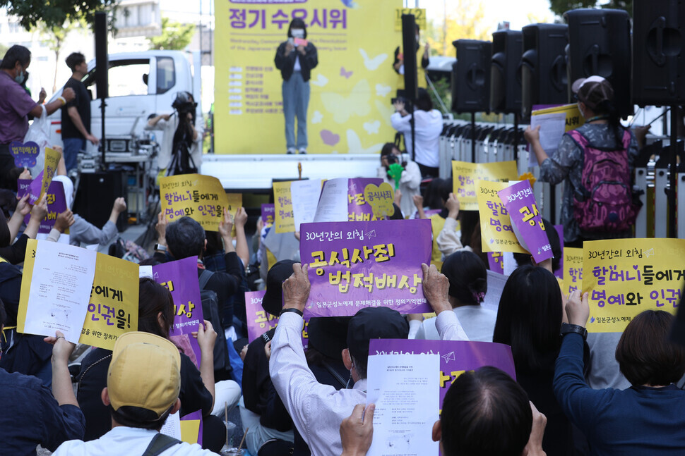 Participants in the 1,562nd Wednesday Demonstration in Seoul hold up signs calling for a formal apology from Japan and legal recompense during their demonstration on Sept. 21 outside the Japanese Embassy in Seoul.