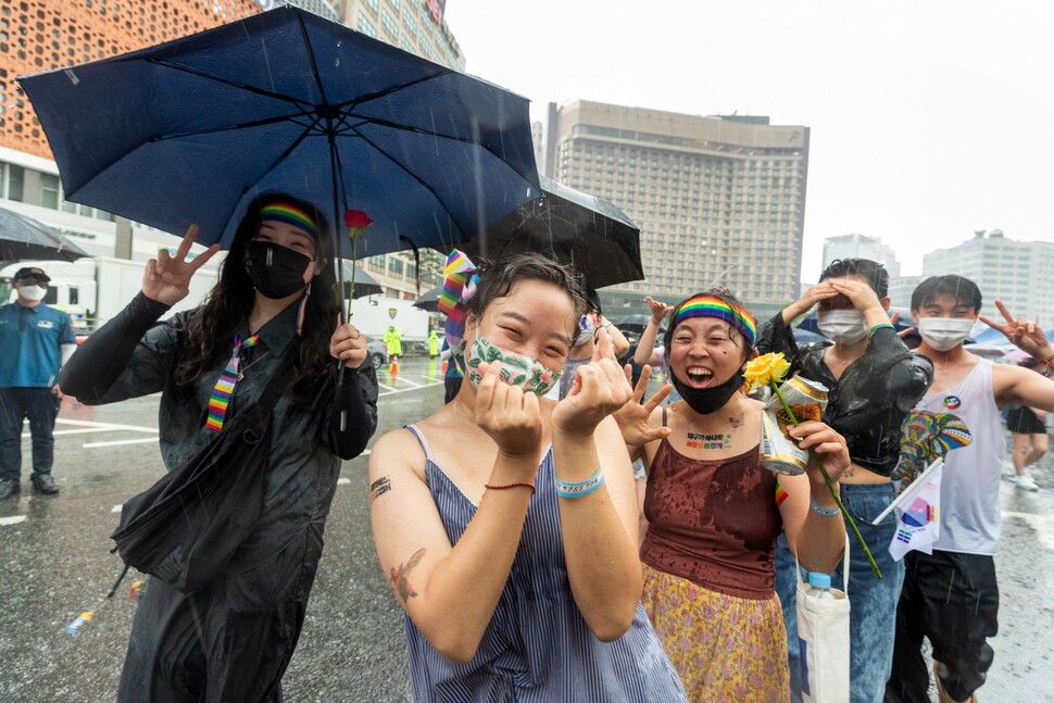 2022년 7월16일 서울퀴어문화축제 참가자들이 서울 을지로 거리에서 비를 맞으며 행진하던 중 카메라를 향해 밝게 웃고 있다. 박승화 기자