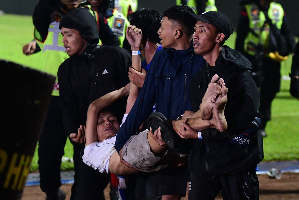 인도네시아 칸주루한 경기장에서 한 관중이 실려나가고 있다. AFP 연합뉴스