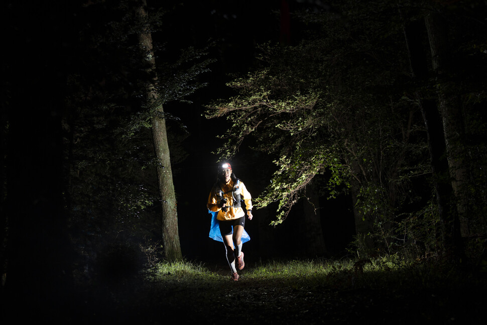 한 참가자가 한라산 인근 어둠이 덮인 오솔길을 헤드랜턴을 켠 채 달리고 있다.