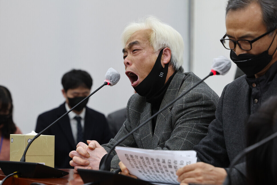 A family member of an individual who was killed in the Itaewon crowd crush sobs as they speak into a microphone during a roundtable with lawmakers at the National Assembly on Dec. 1. (Yonhap)