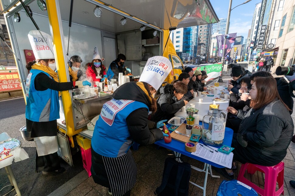 세종호텔 해고노동자들이 성탄절을 앞둔 2022년 12월24일 서울 중구 세종호텔 앞 거리에서 푸드트럭을 빌려 조리한 음식을 노동·시민단체 관계자와 관광객들에게 대접하고 있다.