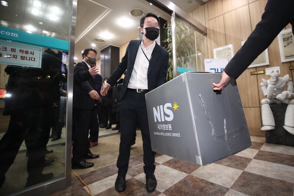 Investigators with the National Intelligence Service carry boxes out after raiding the offices of the KCTU in downtown Seoul on Jan. 18. (Kim Hye-yun/The Hankyoreh)