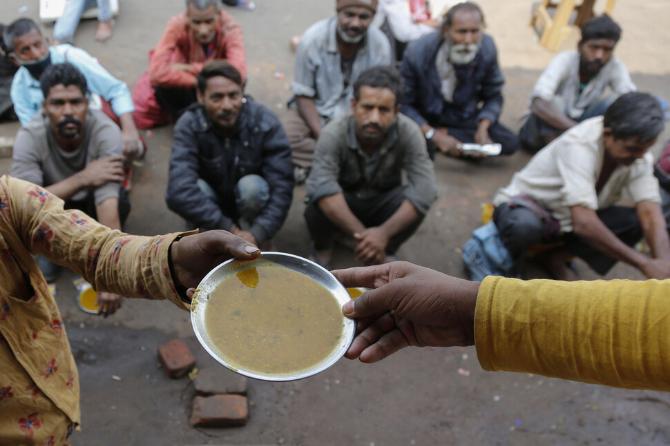2021년 1월20일(현지시각) 인도 아메바다드의 한 식당 밖에서 무료 음식을 기다리는 사람들의 모습. 아메바다드/AP 연합뉴스