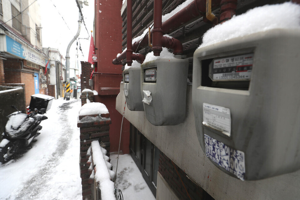 A layer of snow sits atop gas meters in an alleyway in Seoul’s Dongja neighborhood on Jan. 26. (Kang Chang-kwang/The Hankyoreh)