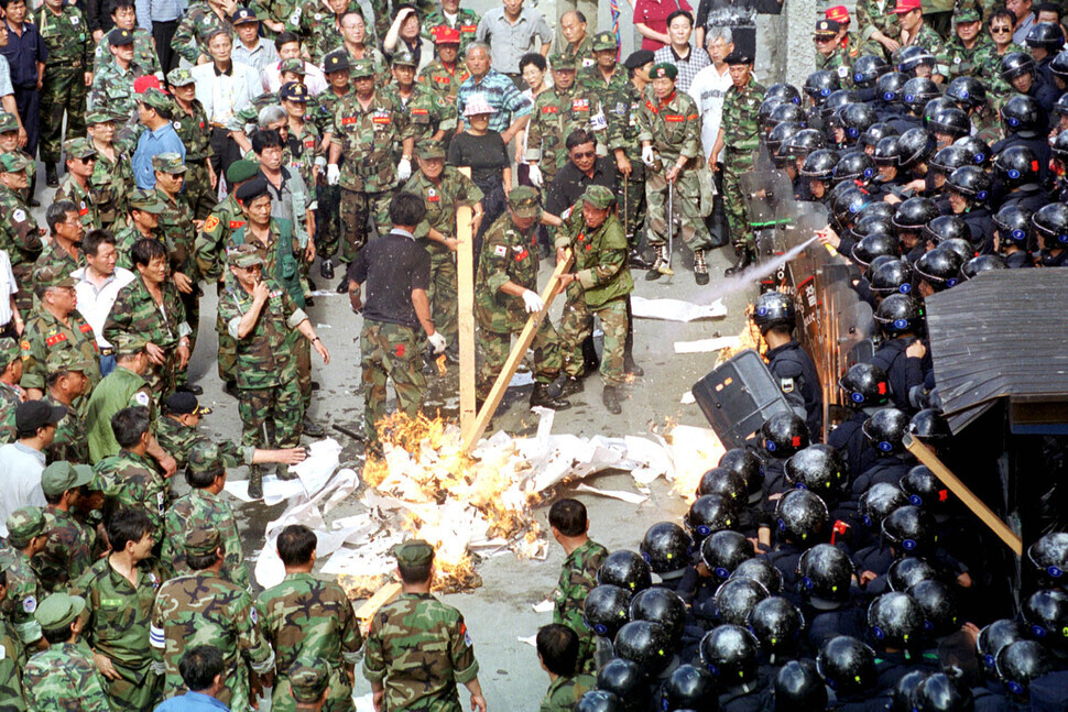Vietnam War veterans harmed by Agent Orange burn papers they dragged from the Hankyoreh’s offices in Seoul’s Gongdeok neighborhood on June 27, 2000, in response to reporting on massacres by Korean troops during the Vietnam War. (Kim Bong-gyu/The Hankyoreh)