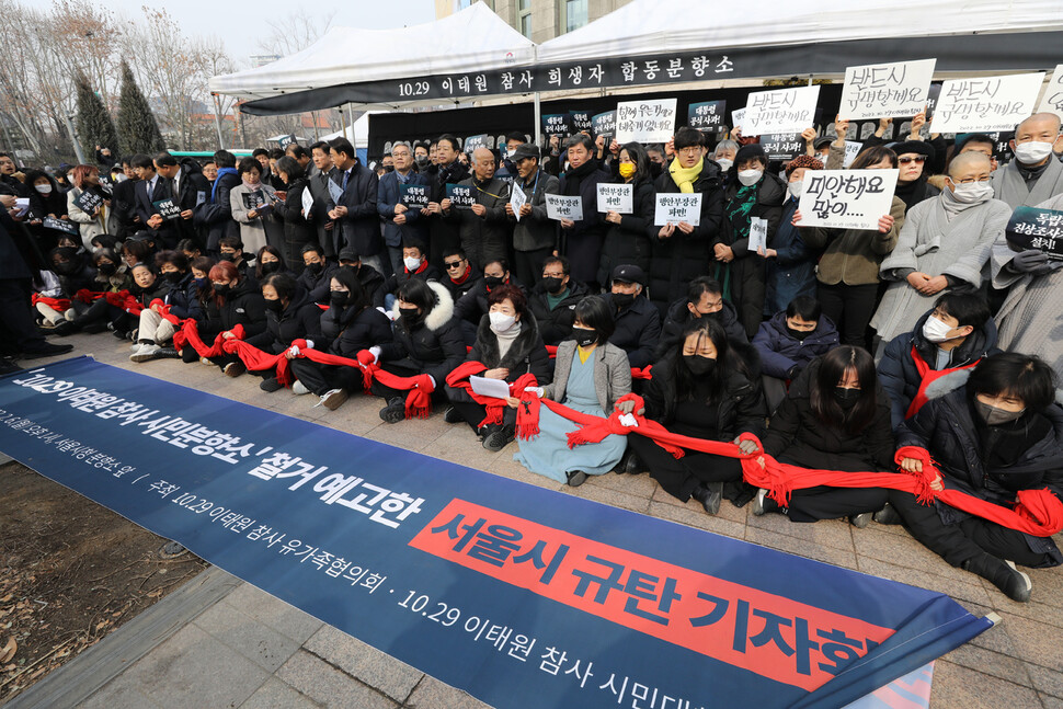 이태원 참사 유가족들이 서울시의 분향소 철거가 예고된 2월6일 오후 자신들이 둘렀던 붉은 목도리를 하나로 이어든 채 분향소 앞을 지키고 있다.