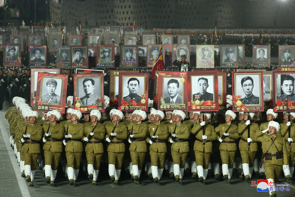 Marchers hold portraits of previous commanders of the Korean People’s Army during the nighttime military parade in Pyongyang’s Kim Il-sung Square held for the 75th founding anniversary of the Korean People’s Army on Feb. 8. (KCNA/Yonhap)