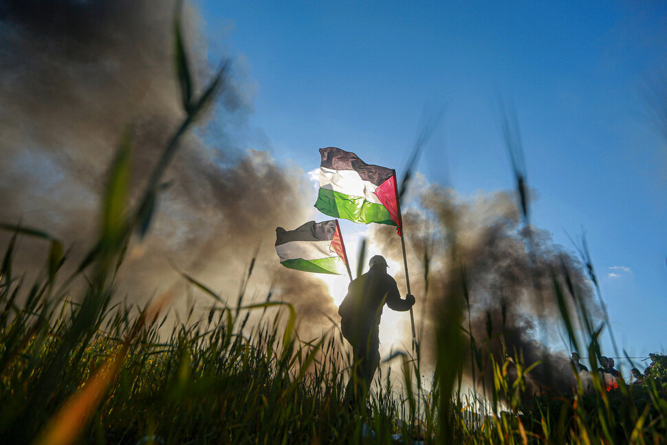 2023년 2월22일(현지시각) 이스라엘군이 팔레스타인 도시 나블루스에 진입해 테러범 수색작전을 하던 중 다수의 사상자가 발생하자 한 남성이 팔레스타인 국기를 든 채 항의하고 있다. 신화 연합뉴스