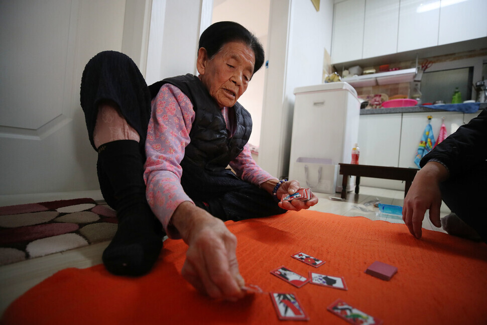 Facing mobility issues, Park Pil-geun spends much of her time playing cards, and playing a round is a must for visitors to her home. (Baek So-ah/The Hankyoreh)
