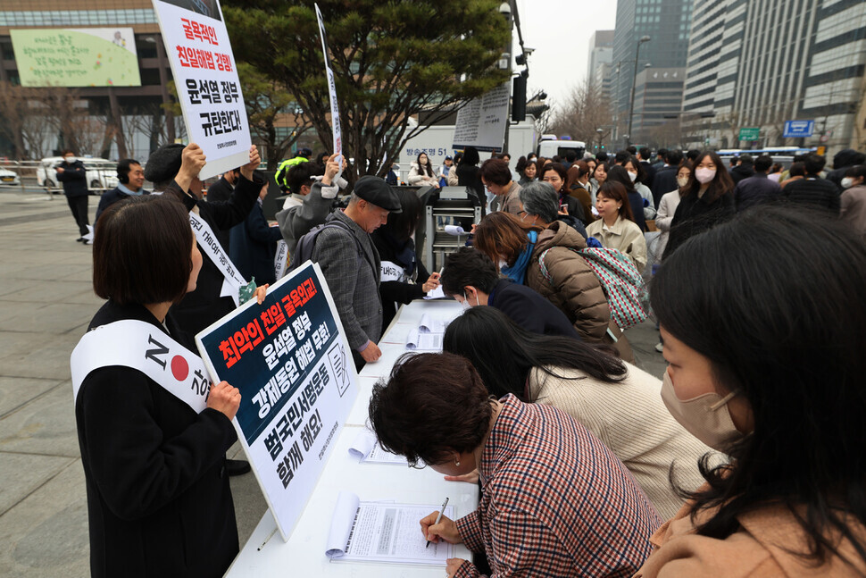Activists with Joint Action for Historical Justice and Peaceful Korea-Japan Relations collect signatures in downtown Seoul on March 9 to void the Yoon Suk-yeol administration’s proposed plan for compensating victims of Japan’s forced labor mobilization. (Kim Hye-yun/The Hankyoreh)
