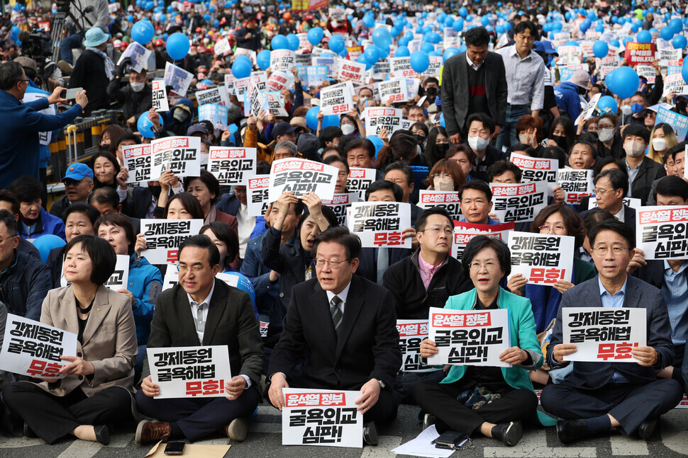 Leaders from the Democratic Party, including Lee Jae-myung (center), and Justice Party leader Lee Jeong-mi (far left), take part in the March 11 rally in Seoul Plaza denouncing the Yoon administration’s plan for compensating forced laborers. (Kim Hye-yun/The Hankyoreh)